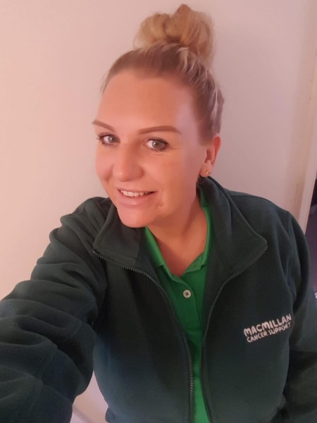 Woman with blonde hair wearing a green polo top and green fleece top